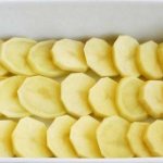 Слой кружочков сырого картофеля в форме