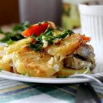 Pike perch baked in the oven with potatoes. Spread the remaining marinade over the potatoes.